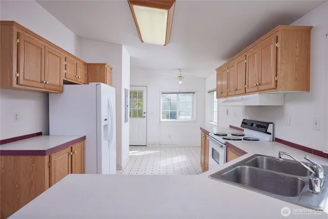 a kitchen that has a sink cabinets and a refrigerator