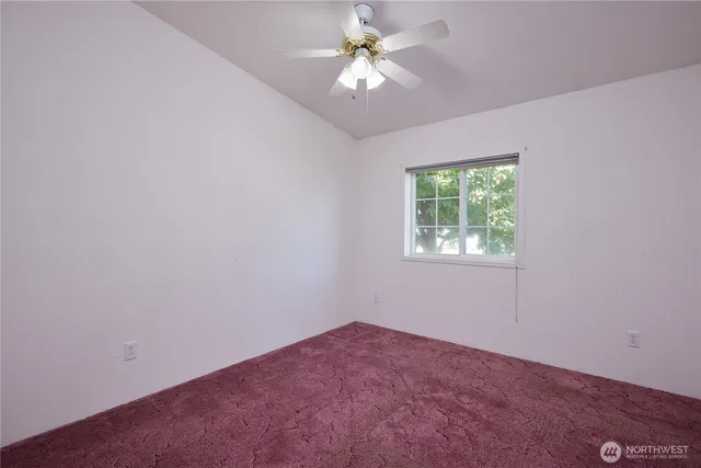 an empty room with a chandelier fan
