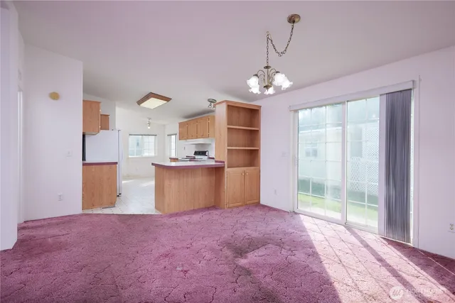 a view of a big room with windows and chandelier