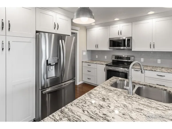 a kitchen with stainless steel appliances granite countertop a refrigerator sink and stove
