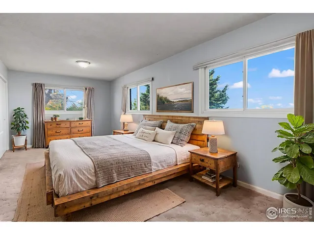 a bedroom with a bed table chair and a window