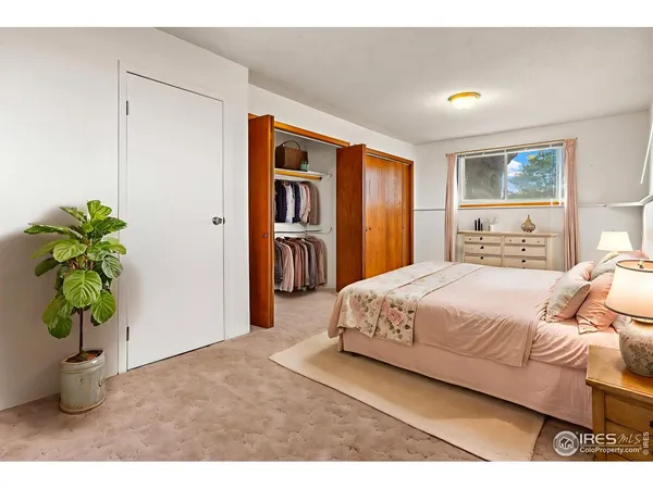 a bedroom with a large bed and a potted plant