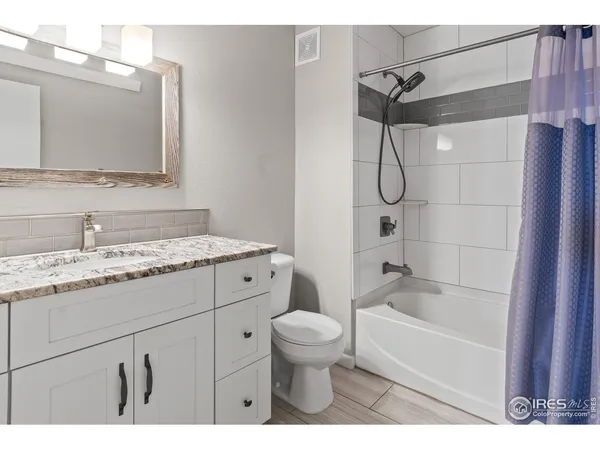 a bathroom with a granite countertop sink a toilet and a bathtub