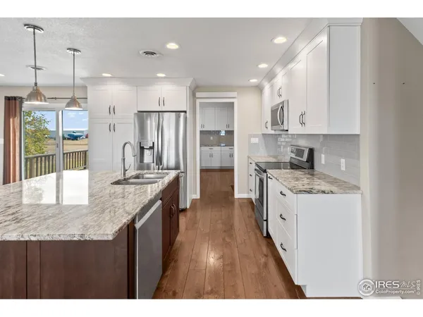 a kitchen with granite countertop a sink a counter top stainless steel appliances and cabinets