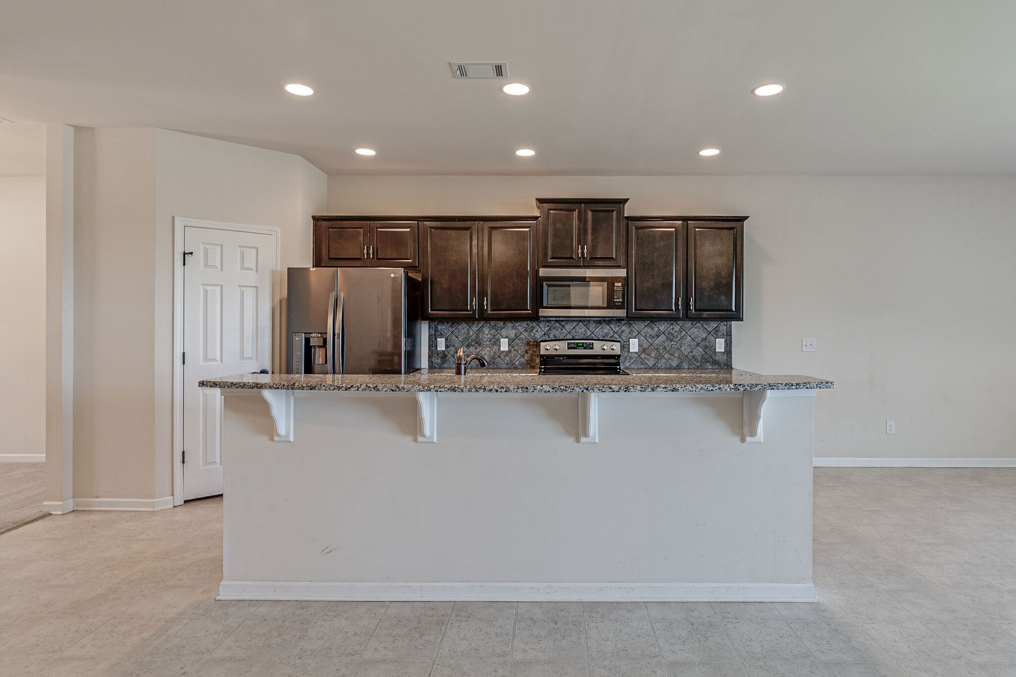 1439 Old Stone Road Lebanon, TN 37087 - Photo 8 of 39 a large white kitchen with stainless steel appliances a refrigerator a stove a microwave and sink