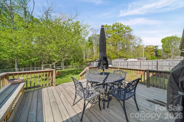 a view of a roof deck with table and chairs with wooden floor and fence