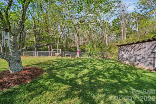 a view of green field with trees in the background