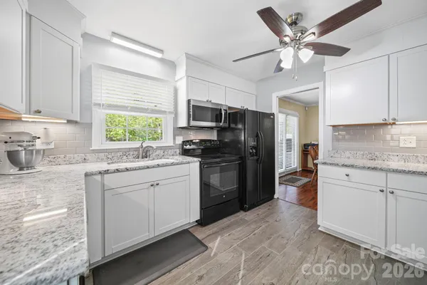 a kitchen with a refrigerator sink and white cabinets