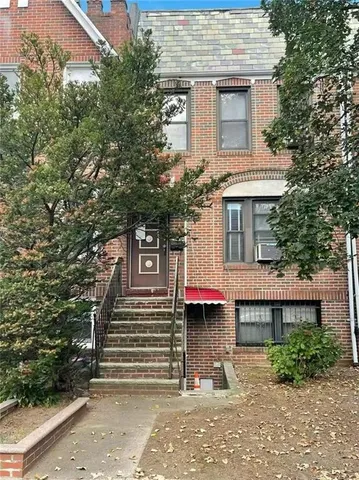 a front view of a house with a tree