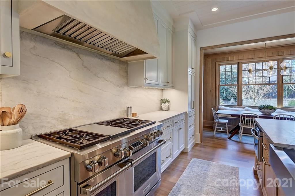 3452 Foxcroft Road Charlotte, NC 28211 - Photo 11 of 48 a kitchen with a stove and wooden cabinets