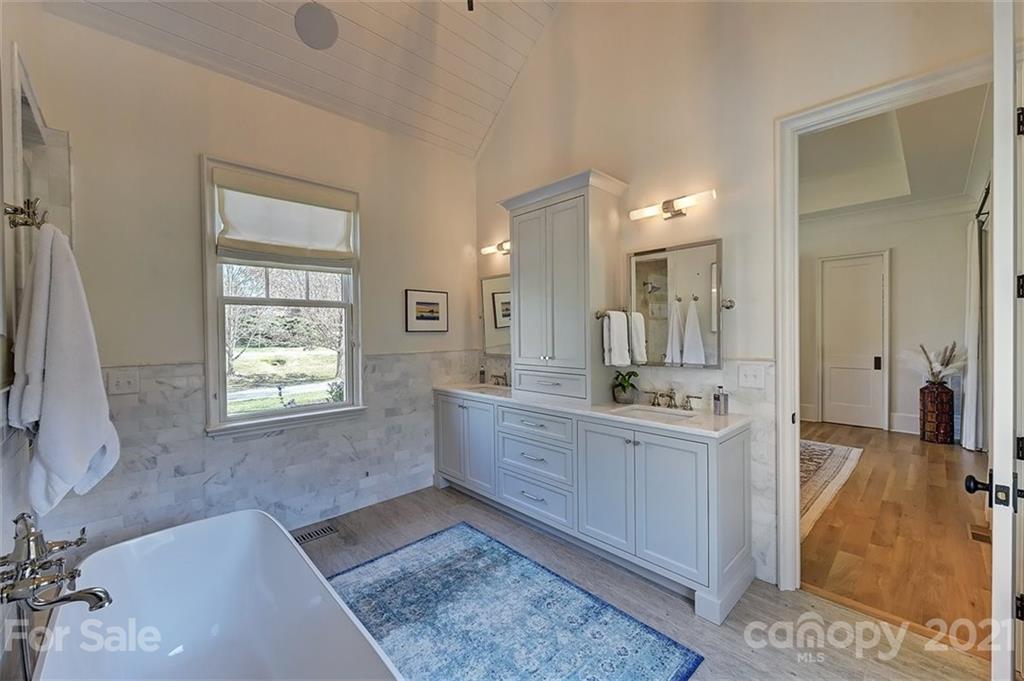 3452 Foxcroft Road Charlotte, NC 28211 - Photo 25 of 48 a large bathroom with a tub sink and mirror