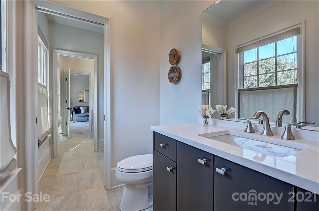 3452 Foxcroft Road Charlotte, NC 28211 - Photo 36 of 48 a bathroom with a granite countertop sink a toilet and a window