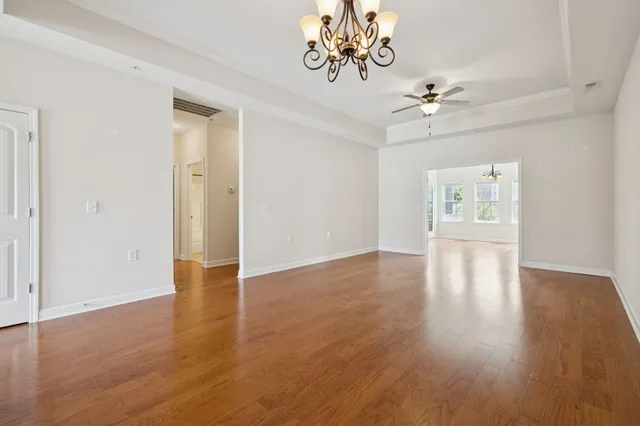 a view of an empty room with a window and wooden floor