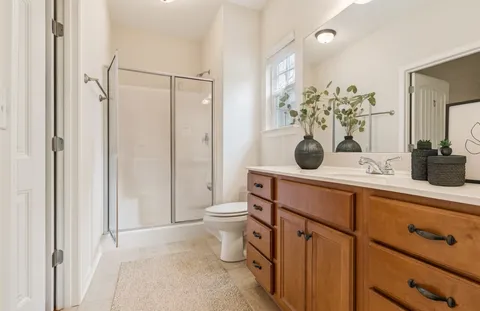 a bathroom with a granite countertop sink a toilet and mirror