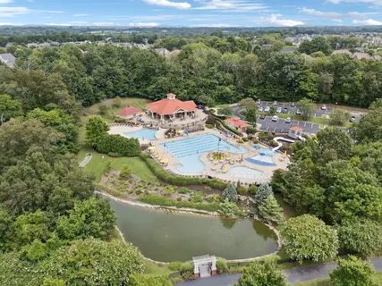an aerial view of a house with a garden and lake view