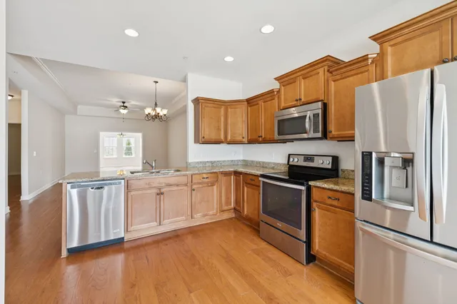 a kitchen with stainless steel appliances granite countertop a refrigerator stove microwave and sink