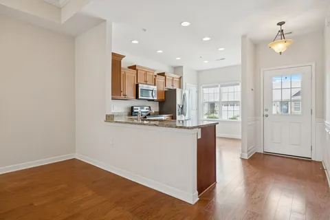 a kitchen with stainless steel appliances granite countertop a refrigerator and a stove top oven