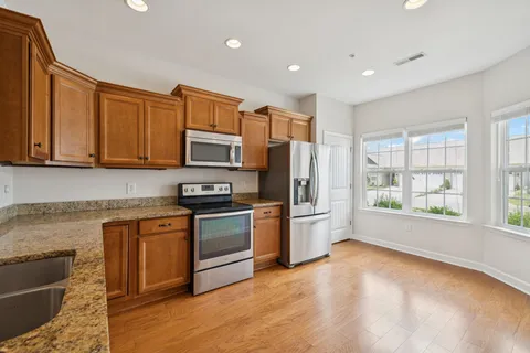 a kitchen with stainless steel appliances granite countertop a stove a sink and a refrigerator