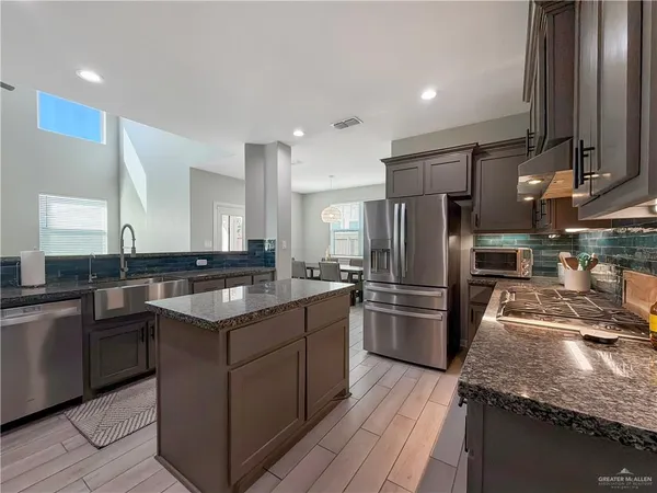 a kitchen with stainless steel appliances granite countertop a sink stove and refrigerator