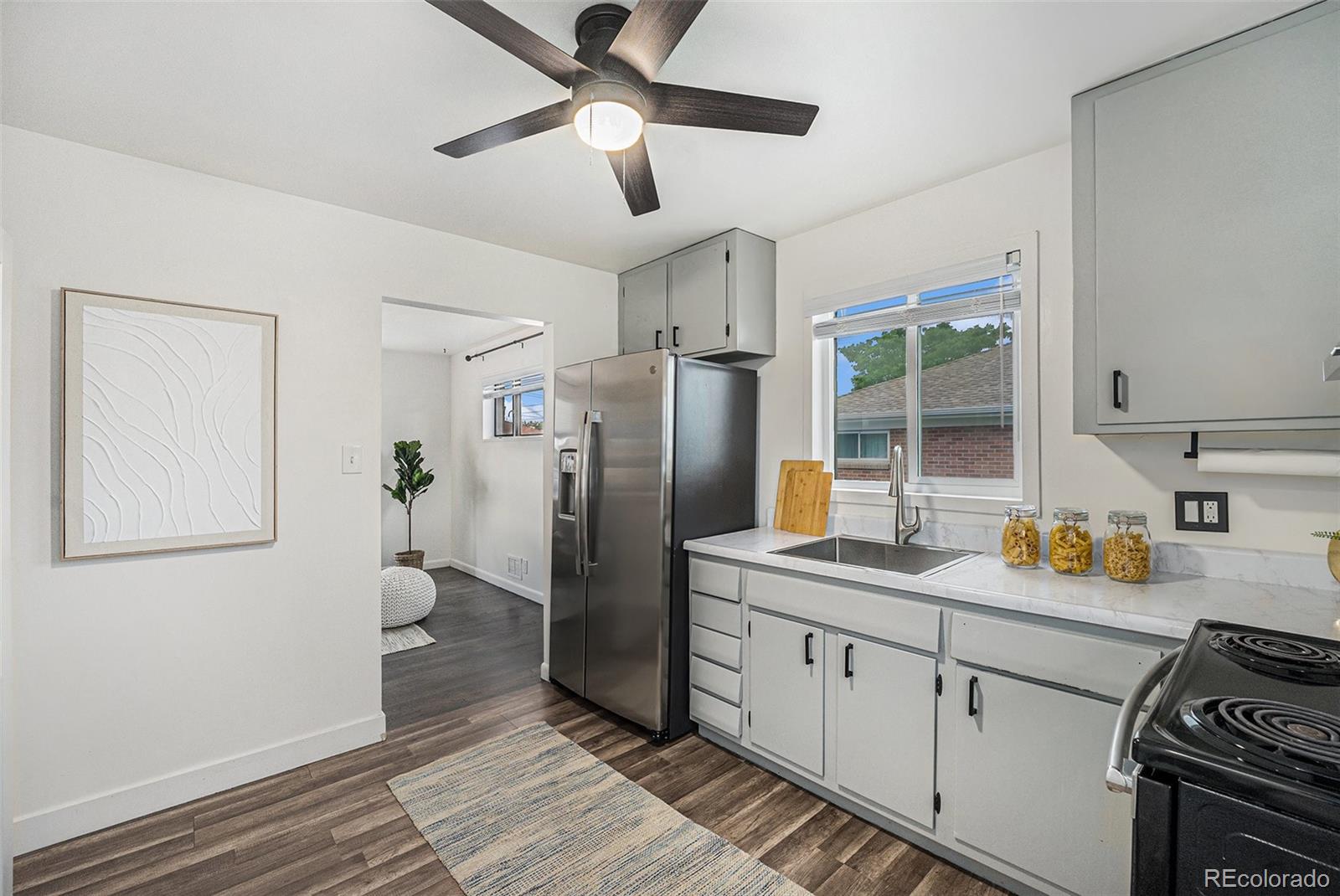 7625 Turner Drive Denver, CO 80221 - Photo 5 of 26 a kitchen with stainless steel appliances a refrigerator a sink a stove and white cabinets