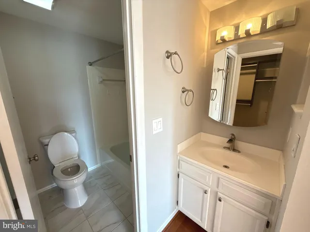 a bathroom with a sink and mirror with toilet