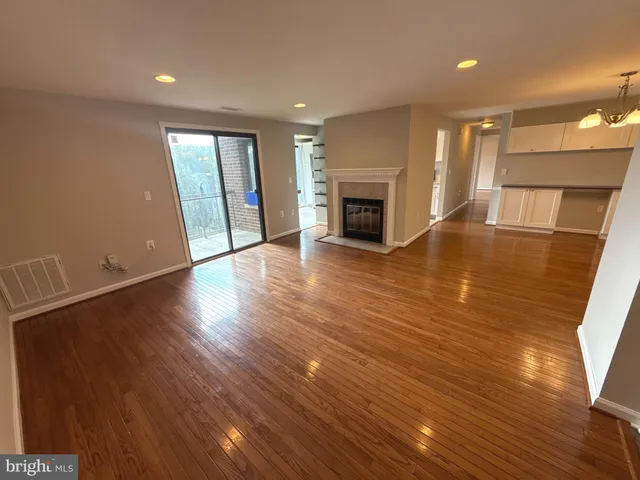 an empty room with wooden floor and fireplace