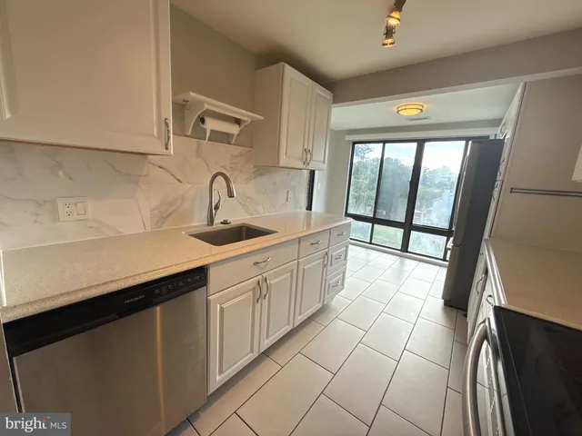 a kitchen with stainless steel appliances granite countertop a sink and a cabinets