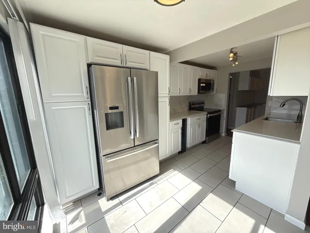 a kitchen with granite countertop a refrigerator and a sink