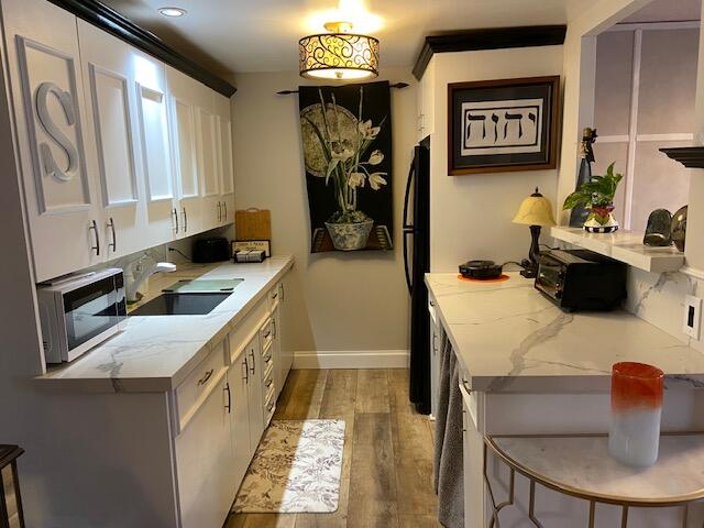 4029 Cornwall East Boca Raton, FL 33434 - Photo 4 of 20 a kitchen with stainless steel appliances granite countertop a sink dishwasher stove top oven a dining table and chairs with wooden floor