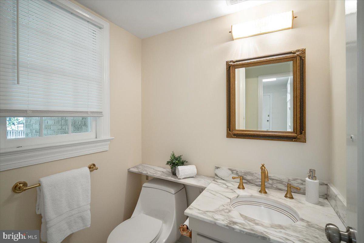6305 Lenox Road Bethesda, MD 20817 - Photo 19 of 49 a bathroom with a granite countertop sink and a mirror