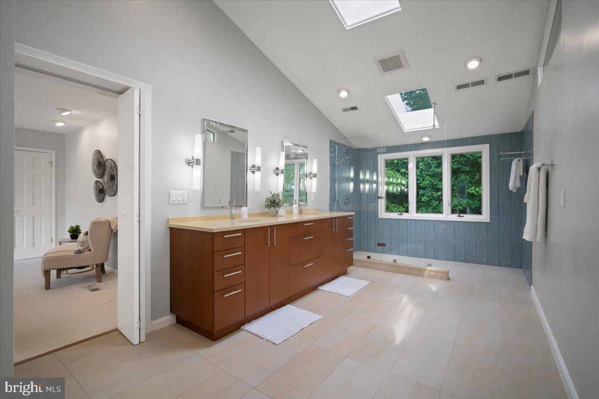 6305 Lenox Road Bethesda, MD 20817 - Photo 26 of 49 a spacious bathroom with a granite countertop sink mirror and window