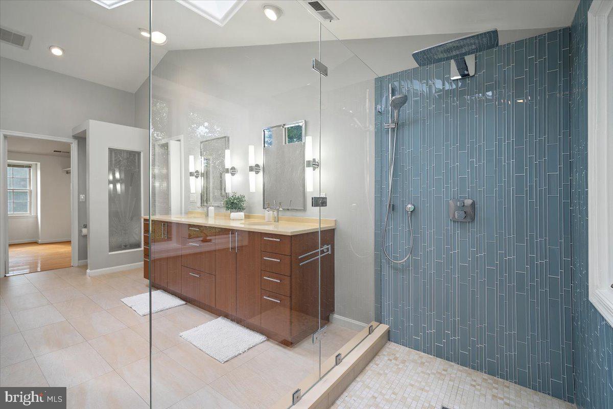 6305 Lenox Road Bethesda, MD 20817 - Photo 27 of 49 a bathroom with a mirror a double vanity sink and glass door