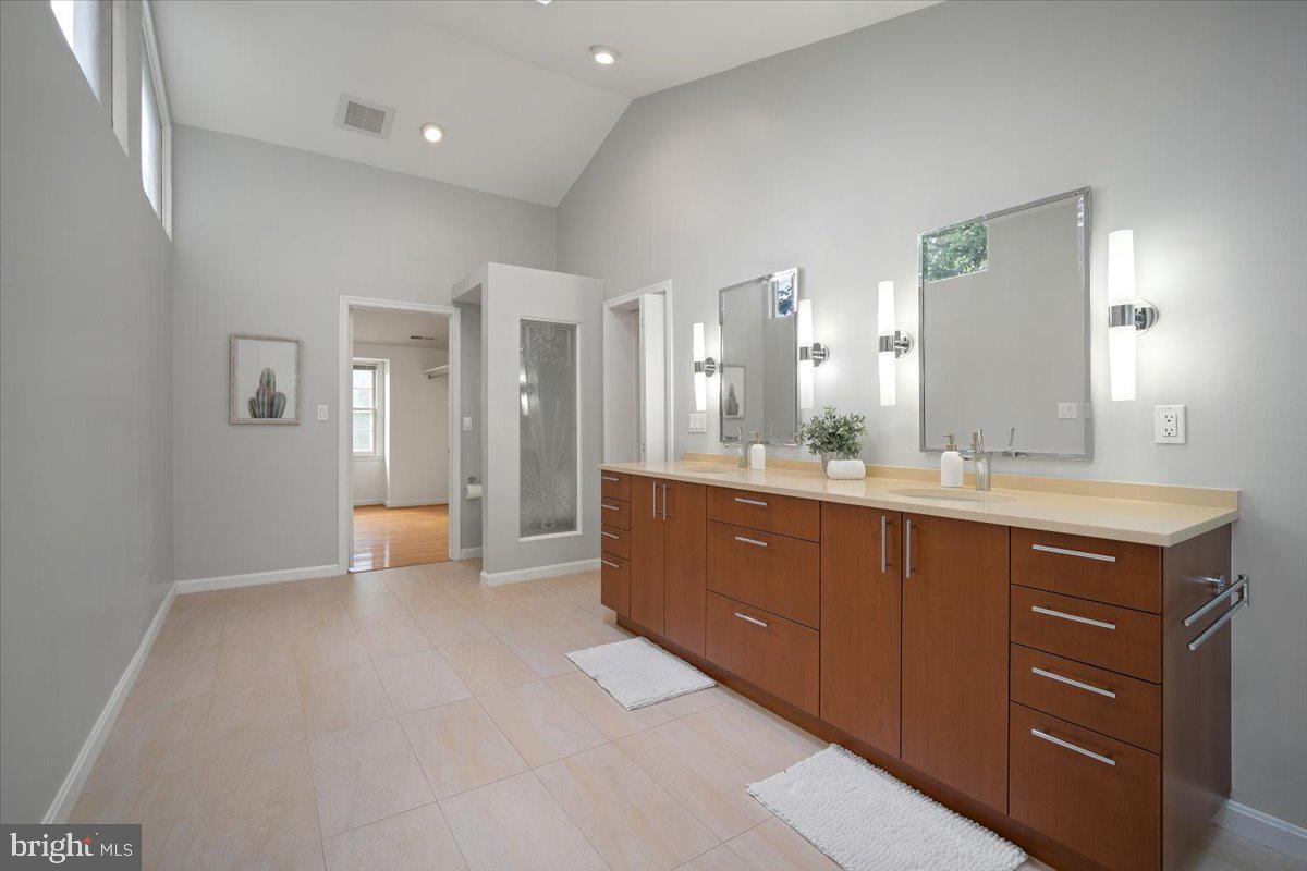 6305 Lenox Road Bethesda, MD 20817 - Photo 28 of 49 a spacious bathroom with a granite countertop sink and a mirror
