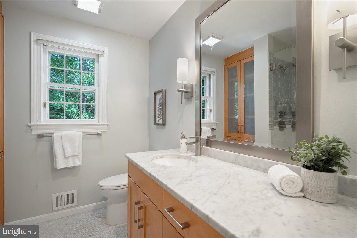 6305 Lenox Road Bethesda, MD 20817 - Photo 30 of 49 a bathroom with a granite countertop sink and a toilet