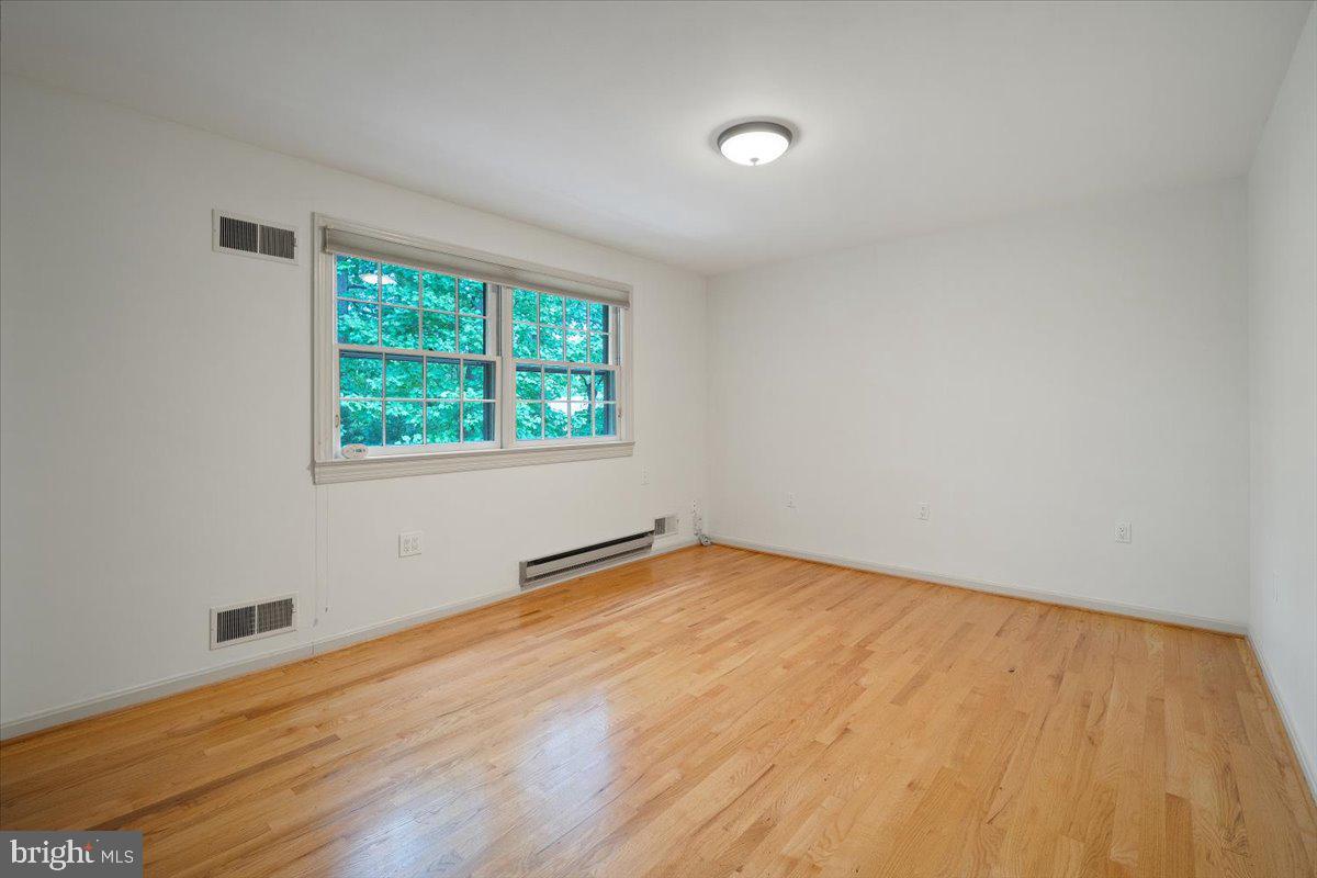 6305 Lenox Road Bethesda, MD 20817 - Photo 33 of 49 an empty room with wooden floor and windows