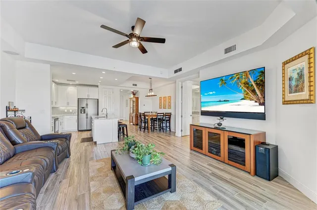 a open kitchen with stainless steel appliances granite countertop a kitchen island a stove a table and chairs