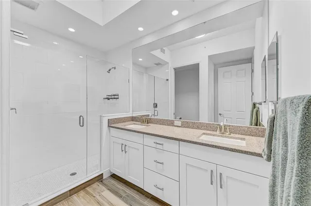 a bathroom with a granite countertop sink a toilet and a shower curtain
