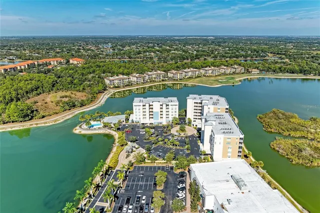 an aerial view of a city with lots of residential buildings ocean and mountain view in back