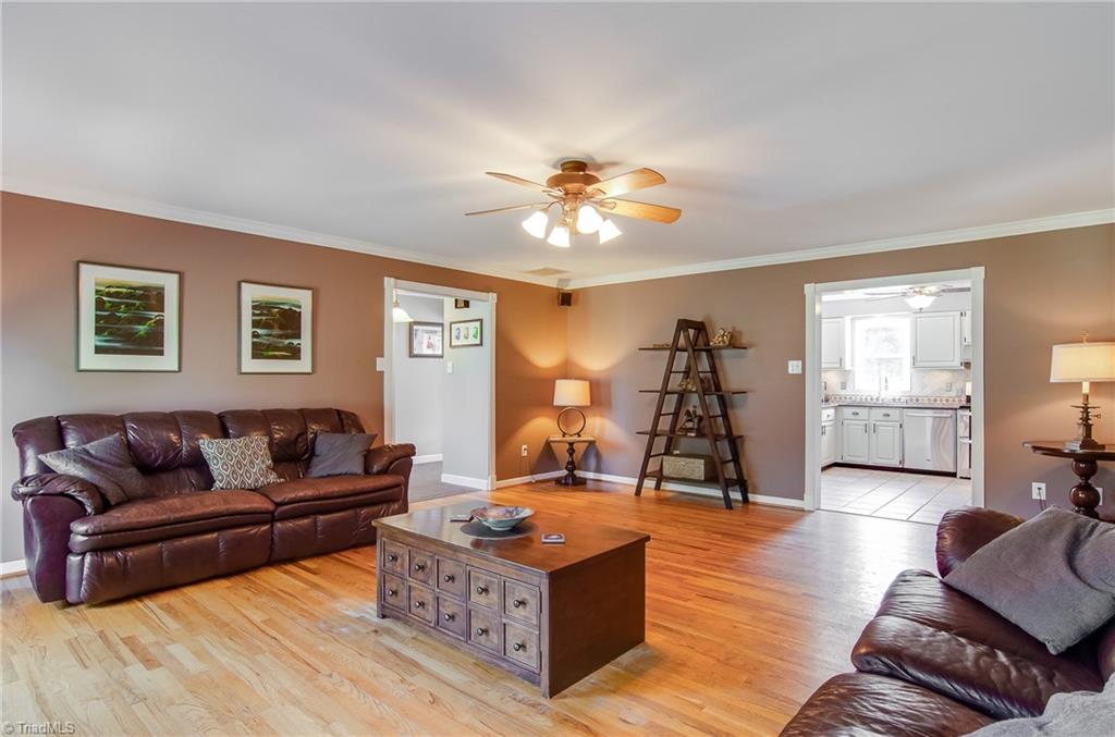 7607 Strawberry Road Summerfield, NC 27358 - Photo 12 of 30 Living room is open to the kitchen. Crown molding is throughout the home. Stereo speakers for your home entertainment.