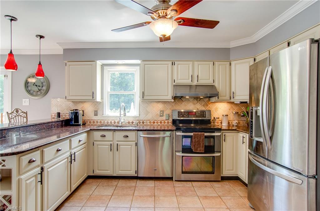 7607 Strawberry Road Summerfield, NC 27358 - Photo 14 of 30 Amazing kitchen has Impressive cabinets with under cabinet lighting, tile floors, granite counter tops and tile back splash. The refrigerator is only several months old.