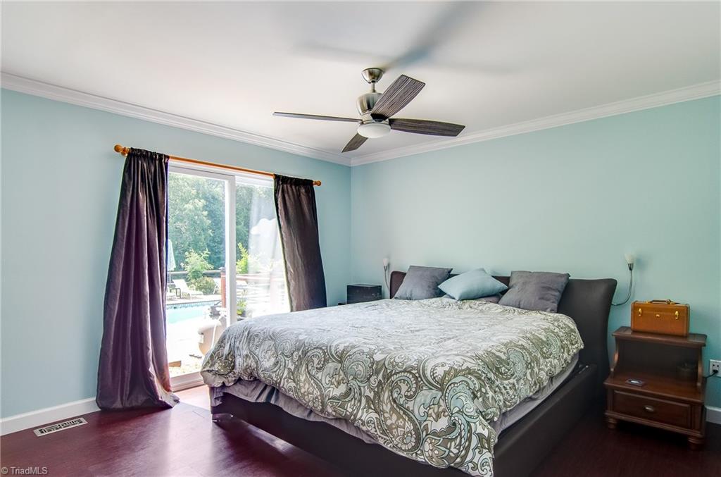 7607 Strawberry Road Summerfield, NC 27358 - Photo 17 of 30 Main level master suite has doors leading to the deck and pool area.