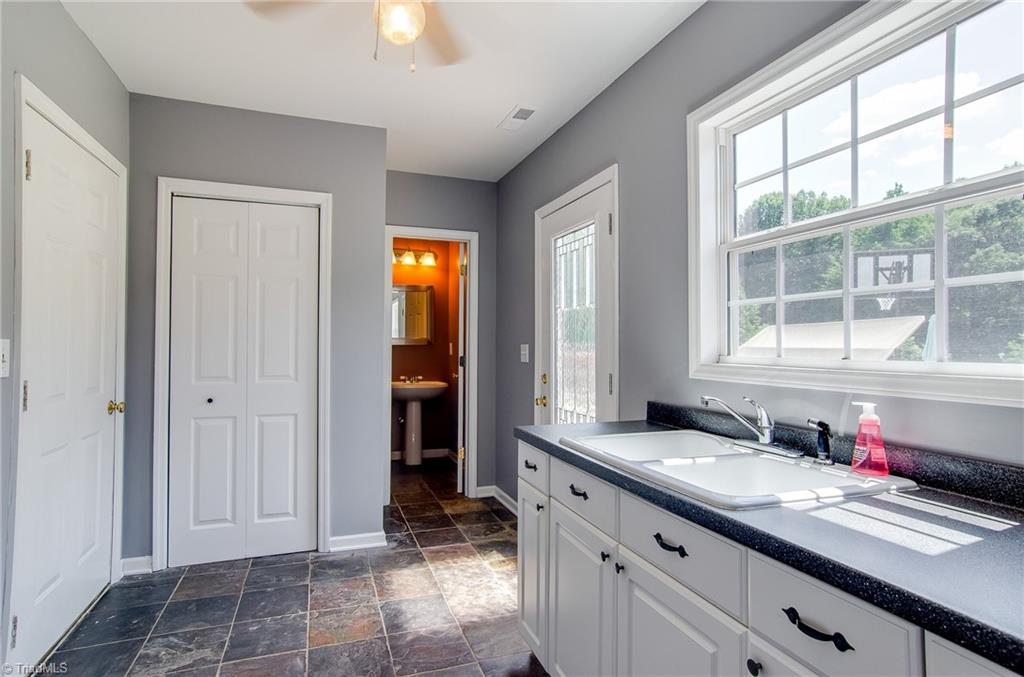 7607 Strawberry Road Summerfield, NC 27358 - Photo 25 of 30 The mud room has a half bath that is convenient for family and quest to use while entertaining outdoors.