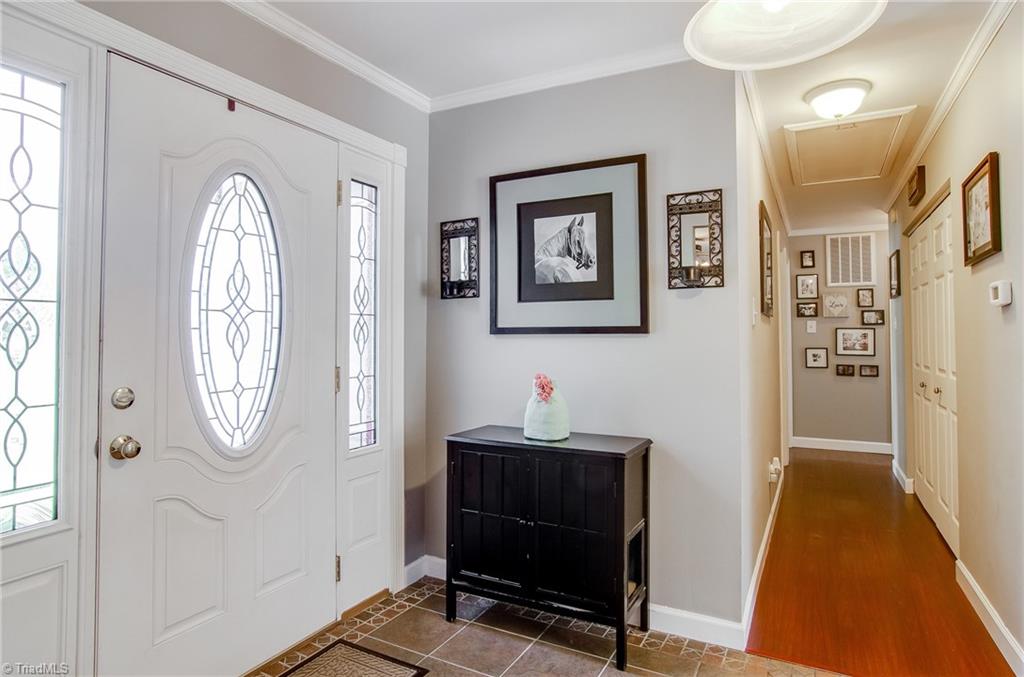 7607 Strawberry Road Summerfield, NC 27358 - Photo 10 of 30 Nice foyer entry with tile flooring and crown molding. Natural light comes through side lights.