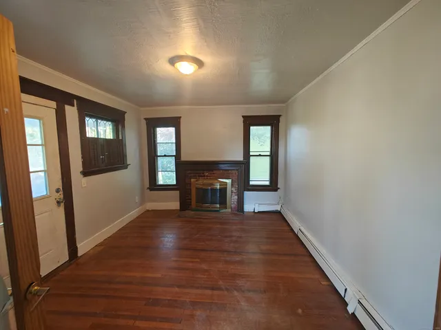 wooden floor in a hall with an entryway and a window