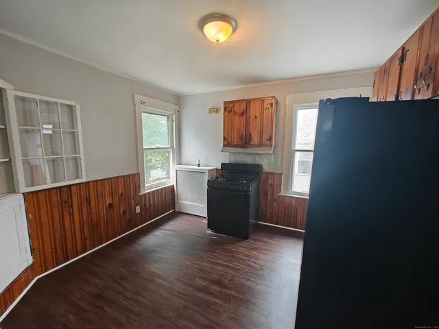 a kitchen with stainless steel appliances granite countertop a refrigerator a sink dishwasher a stove with wooden cabinets and wooden floor