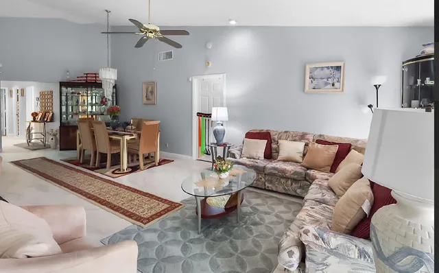 a living room with furniture a flat screen tv and a table