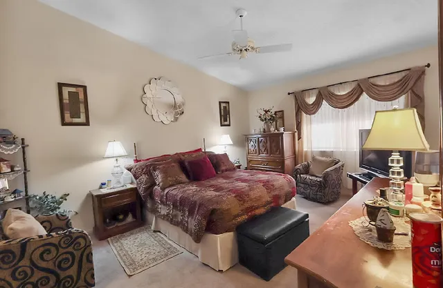 a bedroom with a bed and dresser with mirror