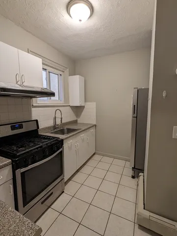 a kitchen with stainless steel appliances granite countertop a stove a refrigerator and a microwave