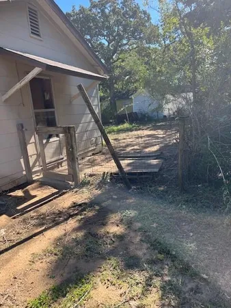 a view of a yard with plants and a slide
