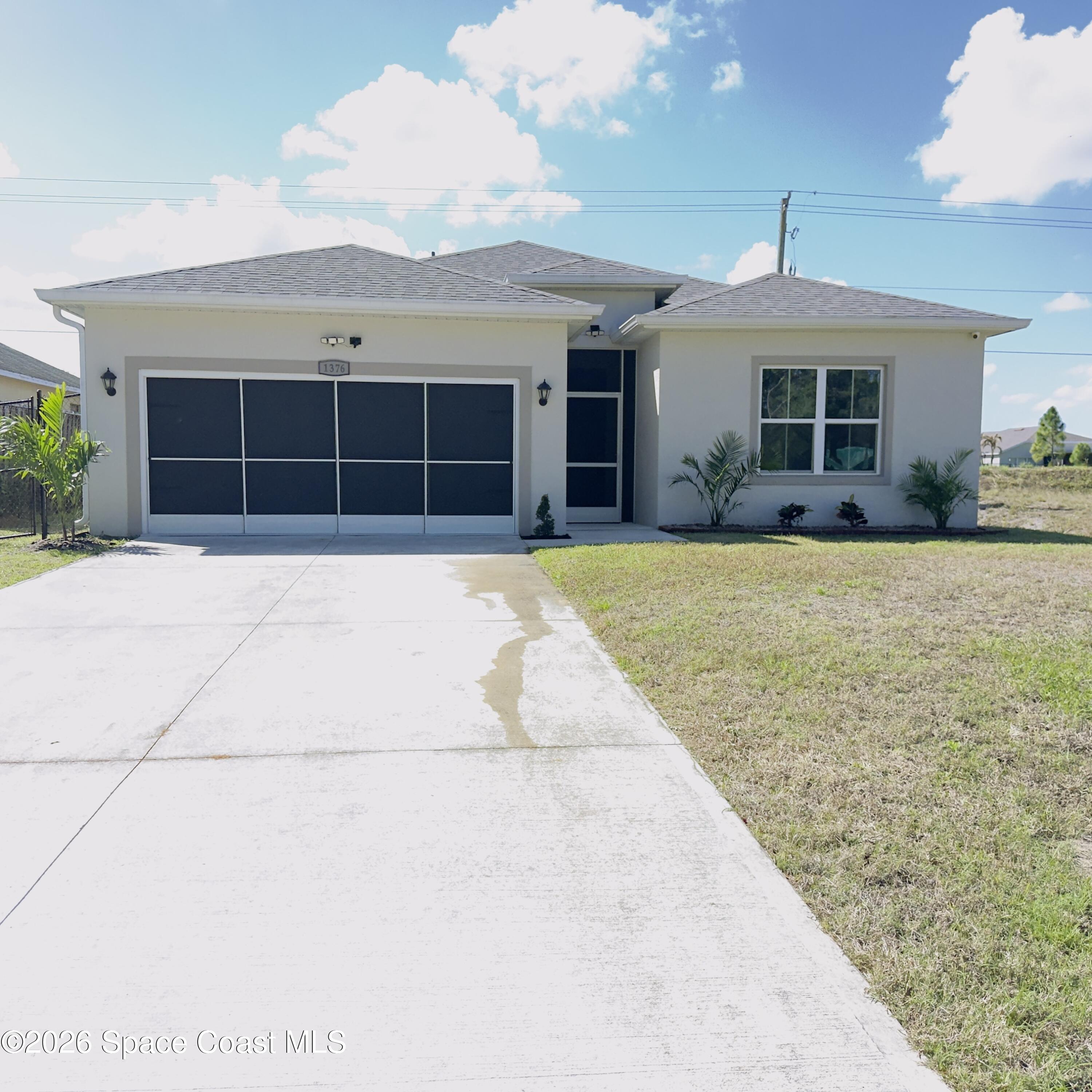 1376 Torgerson Road Southeast Palm Bay, FL 32909 - Photo 1 of 15 a front view of a house with a yard and garage